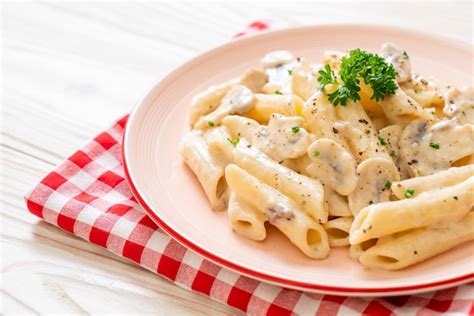 Premium Photo | Penne pasta carbonara cream sauce with mushroom