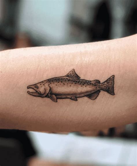 a small fish tattoo on the arm