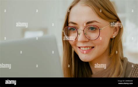 Close up Caucasian woman female face girl in glasses eyes look at laptop screen. Freelancer ...