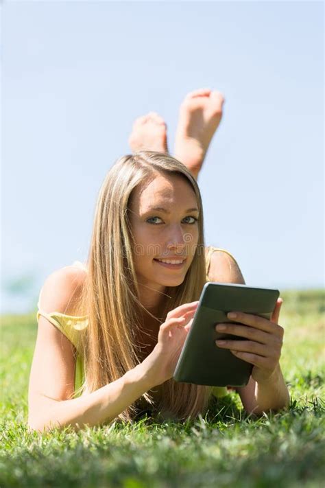 Girl Lying on Grass in Meadow Enjoying Reading Ereader Stock Image ...