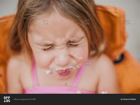 A girl with icing on her face stock photo - OFFSET