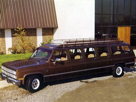 an old brown station wagon parked in front of a building with a metal ...