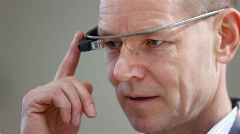 a man with glasses on his head is looking at the camera while he holds his finger up