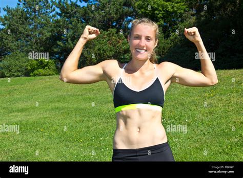 Fit, athletic woman flexing her muscles Stock Photo - Alamy