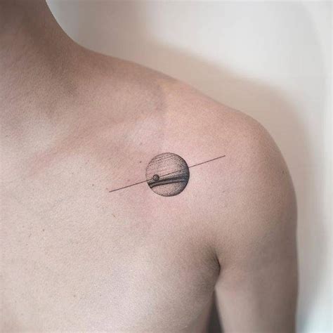 Saturn tattoo on the shoulder.