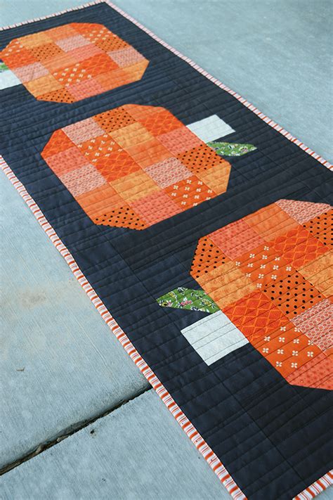an orange and black quilted table runner on concrete