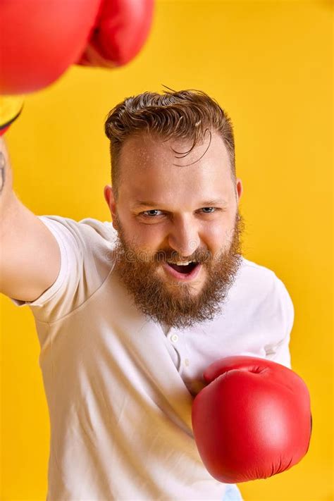 Bearded Emotional Man in Sportswear and Boxing Gloves Against Bright Yellow Background. Winner ...