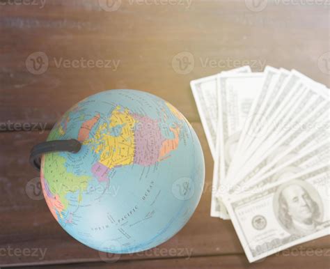 globe with dollar bill on table 7114064 Stock Photo at Vecteezy