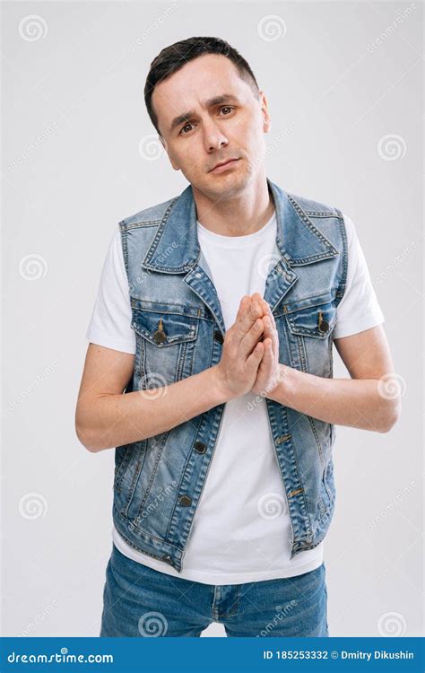 Portrait of Beseeching Man in Denim Clothes Holding Hands in Prayer and ...