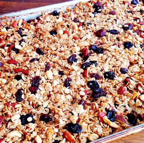 a pan filled with granola and raisins on top of a wooden table