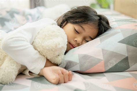 Cute little girl sleeping on bed with soft pillows at home 23740578 Stock Photo at Vecteezy