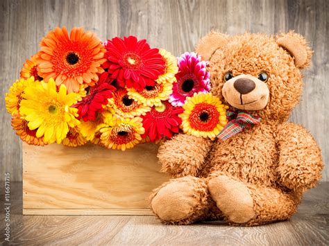 Flowers and a teddy bear on wooden background Stock Photo | Adobe Stock