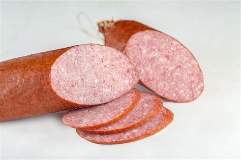 Premium Photo | Whole salami cervelat sausage lie on a vintage kitchen board on a white isolated ...