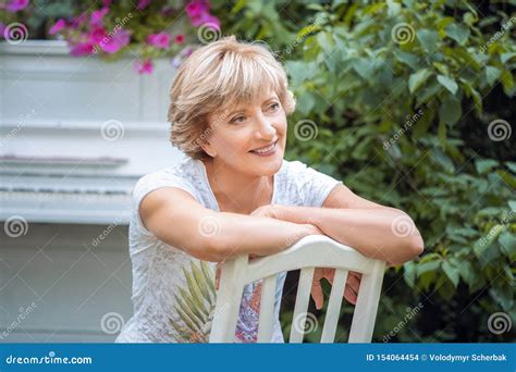 Woman Relaxing Outdoor with a Contented Smile, Looking Up into the Air with a Look of Pleasure ...