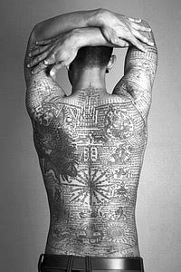 Royalty-Free photo: Person with tattooed skin wearing black denim ...