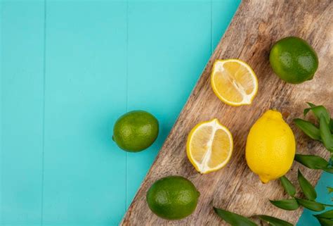 Free Photo | Top view of fresh and colorful lemons on wooden kitchen board on blue