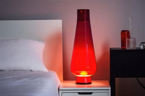 Premium AI Image | Red lava lamp on bedside table in bedroom at night created using generative ...