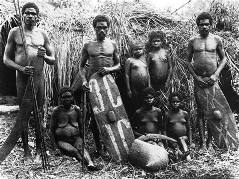 an old black and white photo of some men with surfboards in front of grass