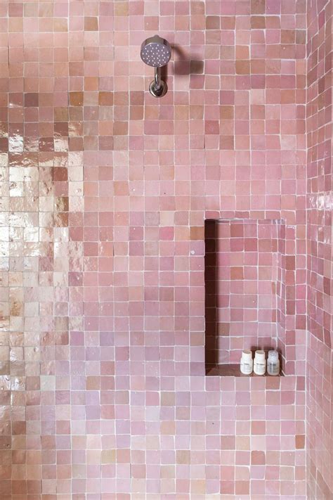 a bathroom with pink tiles on the shower wall