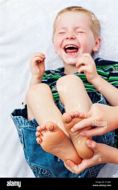 child laughing hysterically while getting feet tickled Stock Photo - Alamy