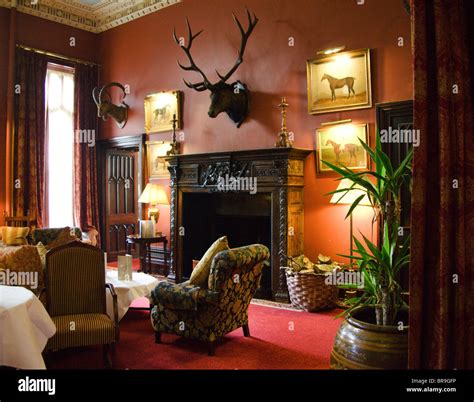 Ireland, the Dromoland Castle the Main Gallery. A red room with hunting mounts and a fireplace ...