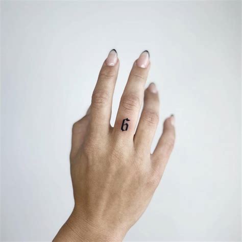 Tattoo of the number "6" located on the finger.