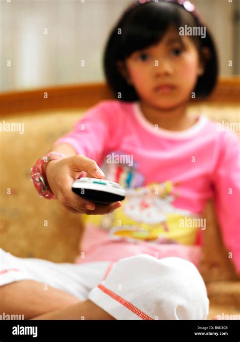 Girl pointing remote control at the camera Stock Photo - Alamy