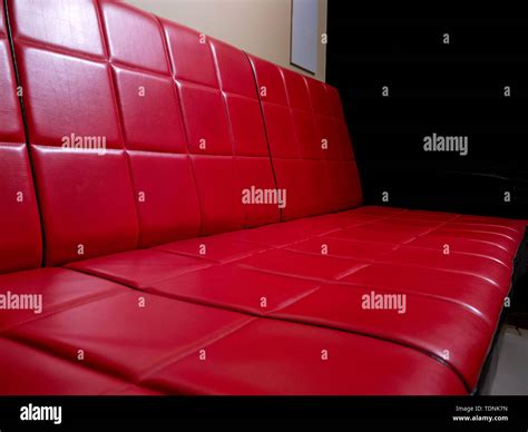 View on a retro red and black faux leather sofa in a room Stock Photo - Alamy