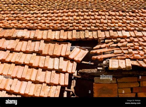 Damaged roof with tiles falling down Stock Photo - Alamy