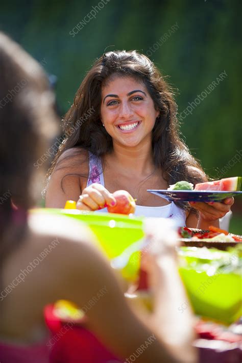 Family eating together outdoors - Stock Image - F006/5546 - Science Photo Library