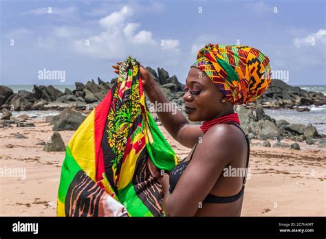 Ghana woman on the beautiful beach of Axim, located in Ghana West Africa. Headdress in ...