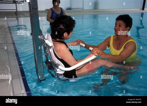 Carer assisting disabled person in swimming pool, Southwark, London Stock Photo: 917863 - Alamy