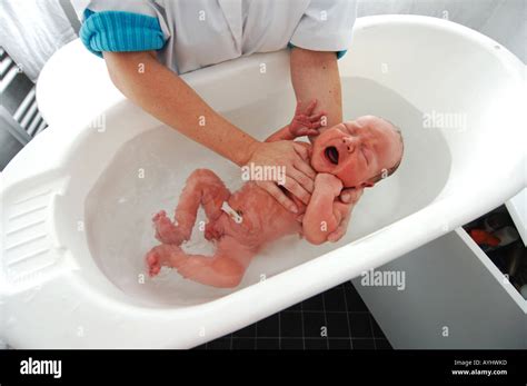 Crying newborn one day old baby boy having his first bath Stock Photo ...