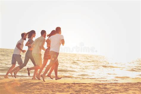 Happy Young People Group Have Fun White Running and Jumping on Beacz at Sunset Time Stock Image ...