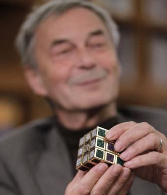 Erno Rubik, the inventor of the Rubik's Cube, poses with a cube made of [gold, gemstones, and ...