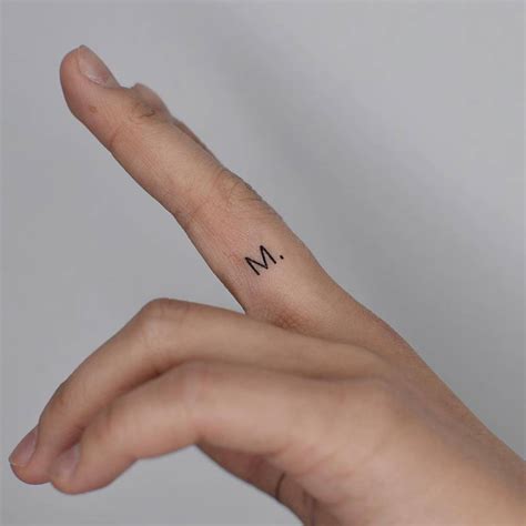 Letter "M" tattooed on the finger