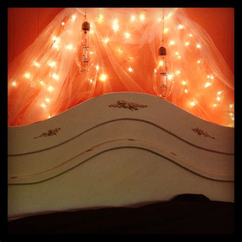 Twinkle lights, wedding veil, and vintage lightbulbs make an ethereal and quirky headboard ...