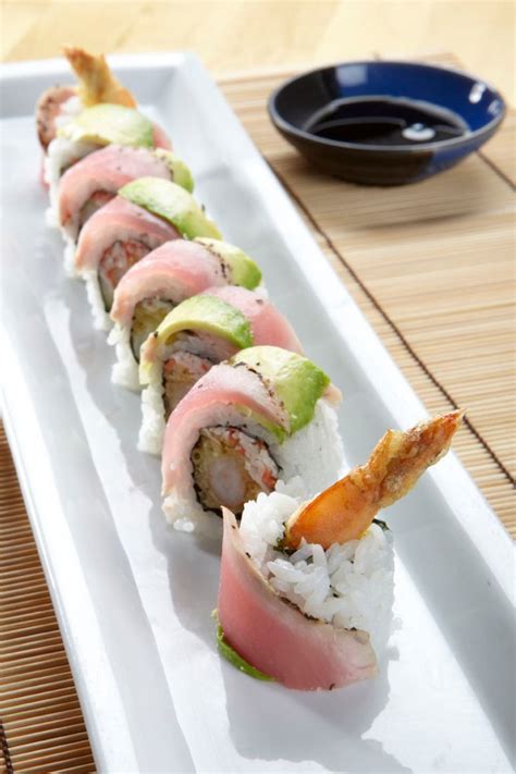 Shrimp tempura with spicy crab mix and cucumber, rolled and topped with seared tuna and avocado ...