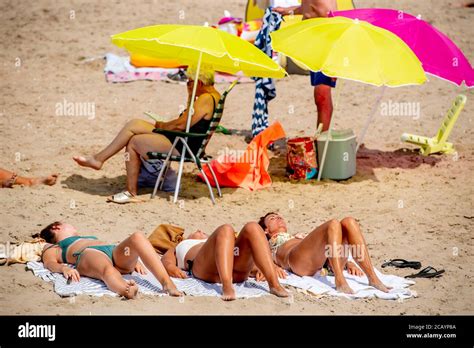 People sunbathing during the hot weather.The beach is busy and ...