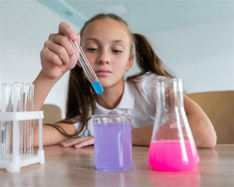 Premium Photo | A schoolgirl conducts experiments in a chemistry lesson girl pouring colored ...