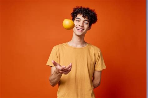 Premium Photo | Handsome man with curly hair oranges in hands studio ...