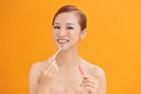 Attractive and Beautiful Asian Girl Paint Lips a Pink Lipstick and Looking at the Camera Stock ...