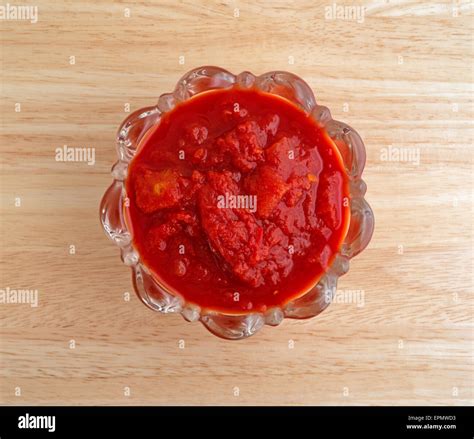 Top view of a bowl of crushed jalapeño peppers and tomatoes on a wood table top Stock Photo - Alamy