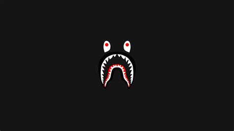 a shark's mouth with red eyes and sharp teeth on a black background,