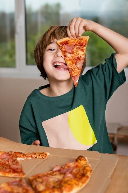 Premium Photo | Kid having fun while eating pizza