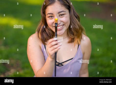 Petite Young Asian Woman Student Holding a Paint Brush with Yellow Acrylic Paint Stock Photo - Alamy