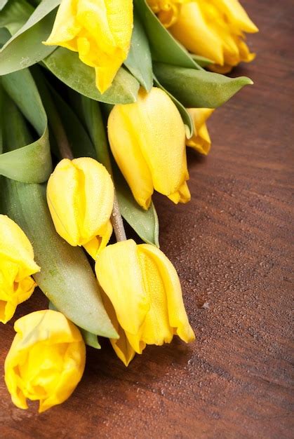 Premium Photo | Yellow tulips bright spring flowers on wooden background