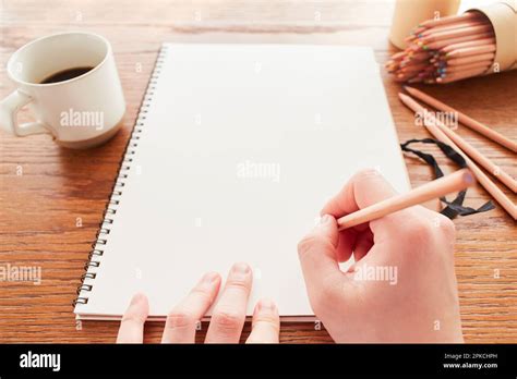 Hand of a man trying to draw a picture in a sketchbook on a table Stock Photo - Alamy