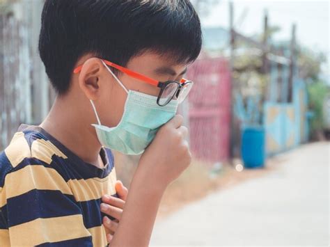 Premium Photo | Close-up of boy wearing pollution mask in city