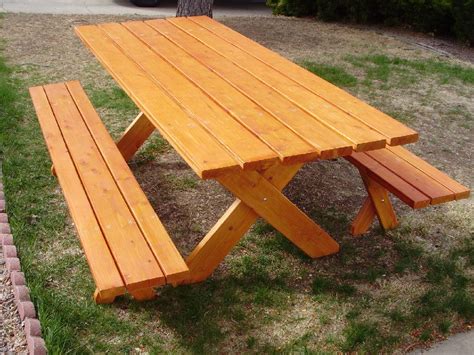 a wooden picnic table sitting in the grass